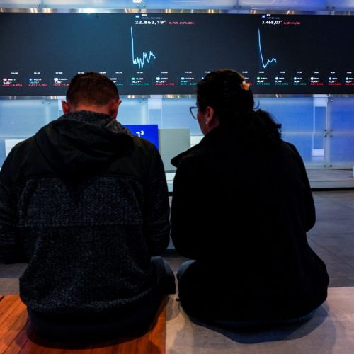 Pessoas observam painéis eletrîonicos na B3, em São Paulo 10/07/2025 REUTERS/Alexandre Meneghini