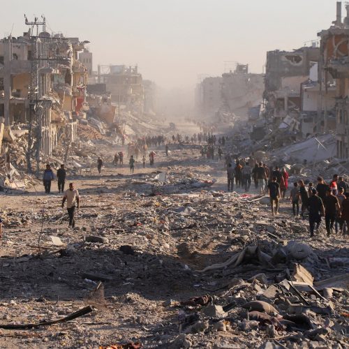 Palestinos caminham em meio a destroços na Cidade de Gaza 10/10/2025 REUTERS/ Ebrahim Hajjaj