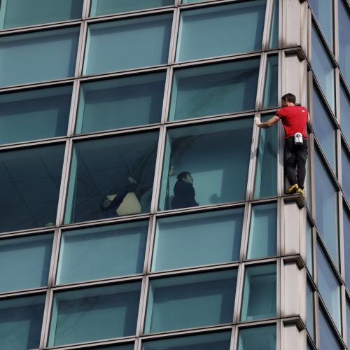 O escalador Alex Honnold acena para os espectadores dentro do Taipei 101 enquanto realiza a escal...