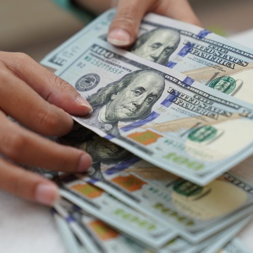 Um trabalhador conta notas de dólar americano em uma casa de câmbio em Jacarta, Indonésia, na ...